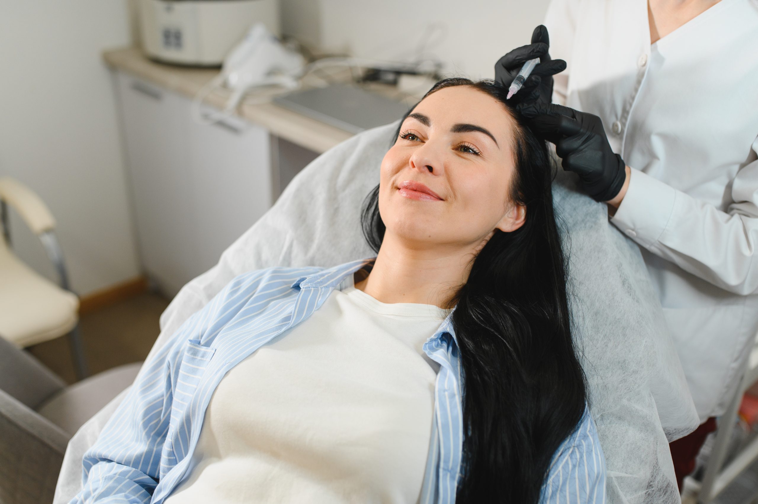 Beautiful middle woman receiving hair mesotherapy injection from competent beautician